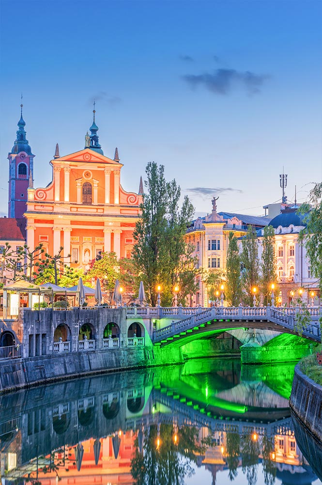 Evening view of Ljubljana featuring the Franciscan Church and Triple Bridge, Slovenia.
