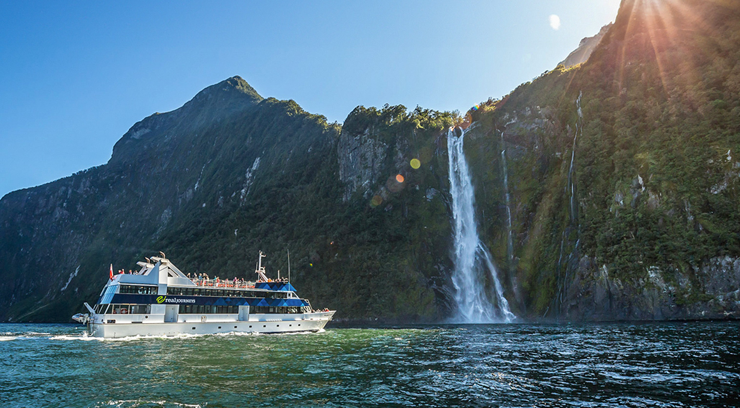 Sailing beneath towering cliffs and waterfalls