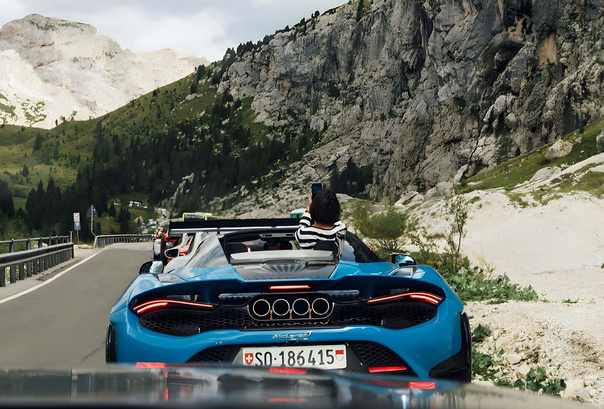 Convertible supercar driving through the Italian Alps.